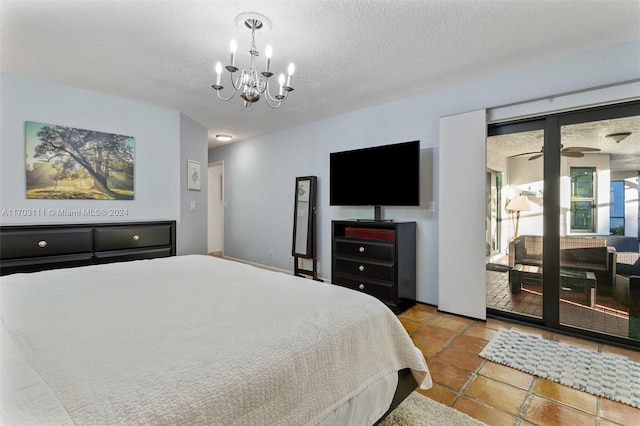 bedroom featuring access to outside, a textured ceiling, and an inviting chandelier