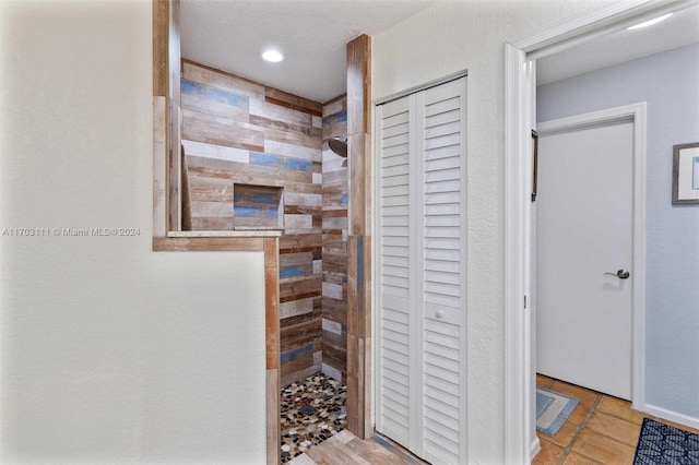 bathroom featuring a tile shower and a textured ceiling