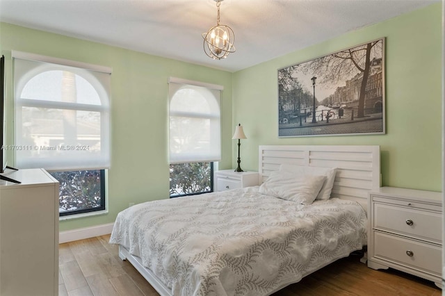 bedroom featuring light hardwood / wood-style floors and a notable chandelier