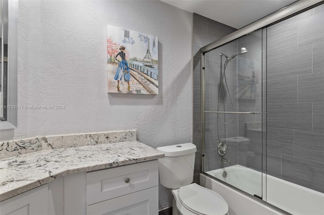 full bathroom featuring vanity, toilet, and shower / bath combination with glass door