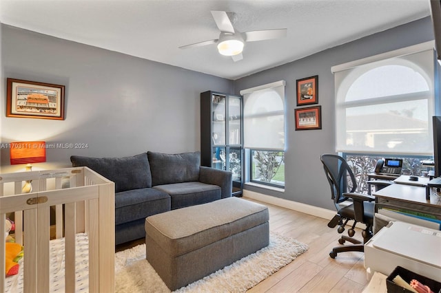 home office with light wood-type flooring and ceiling fan