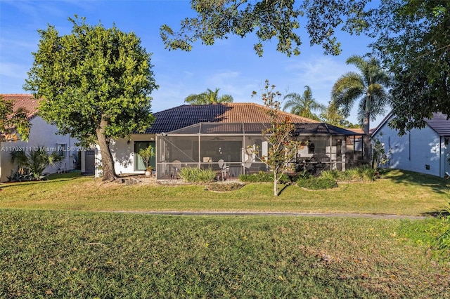 back of house featuring a lawn and glass enclosure