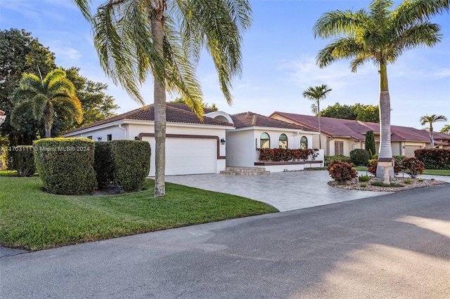 mediterranean / spanish-style house with a garage and a front lawn