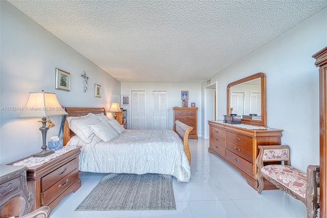 tiled bedroom featuring a textured ceiling