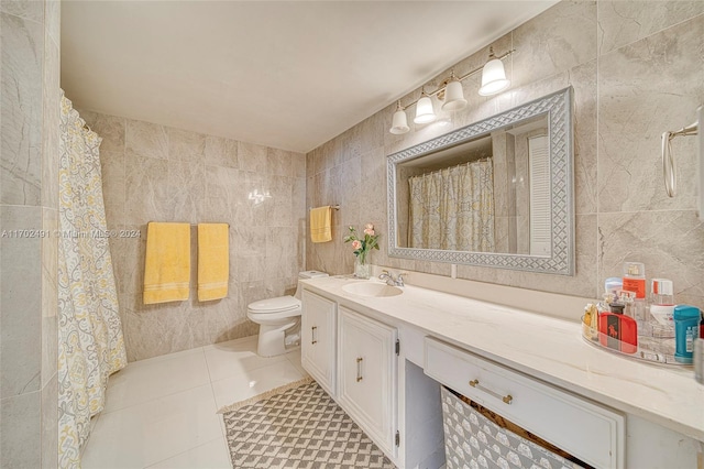 bathroom featuring tile patterned flooring, vanity, toilet, and tile walls