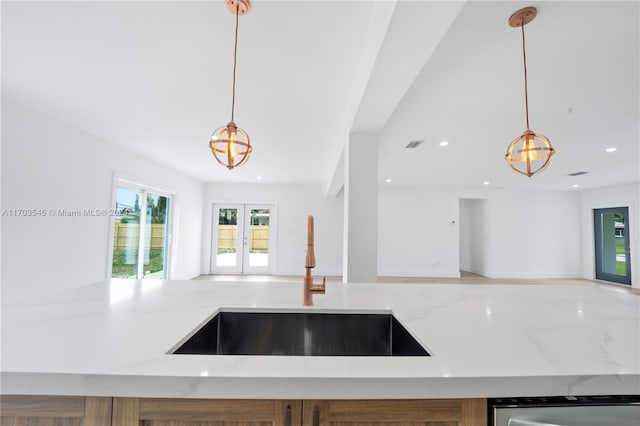 kitchen featuring dishwasher, hanging light fixtures, and sink