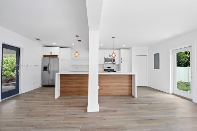 kitchen featuring plenty of natural light, a center island, white cabinetry, and stainless steel appliances