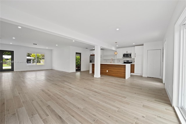 unfurnished living room with light hardwood / wood-style floors and sink