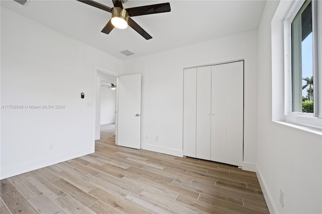 unfurnished bedroom with ceiling fan, light hardwood / wood-style floors, and a closet