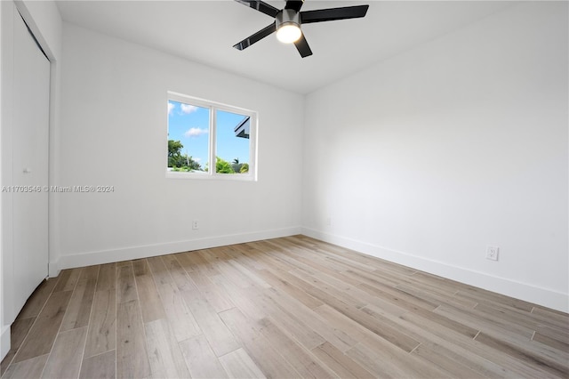 spare room with ceiling fan and light wood-type flooring