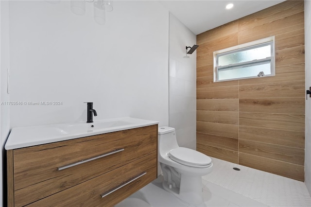 bathroom featuring vanity, toilet, and a tile shower