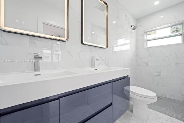 bathroom featuring vanity, toilet, tiled shower, and tile walls