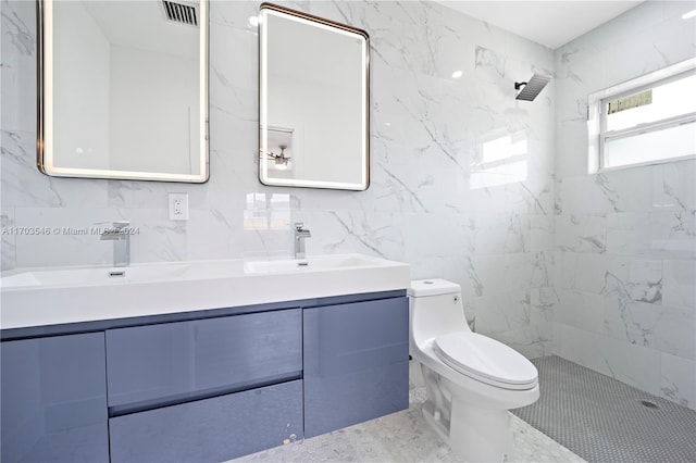 bathroom featuring a tile shower, vanity, toilet, and tile walls