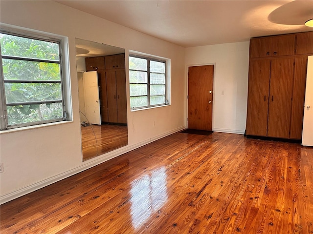 unfurnished bedroom featuring hardwood / wood-style flooring and multiple windows