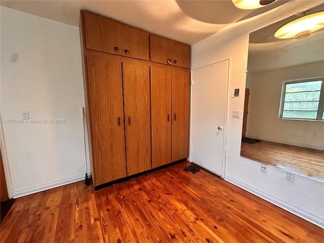 unfurnished bedroom featuring a closet and dark wood-type flooring