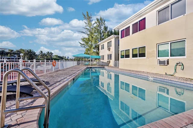 view of pool with an AC wall unit