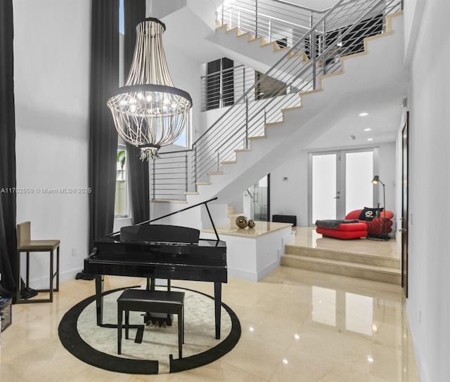 foyer featuring a towering ceiling, french doors, and a chandelier