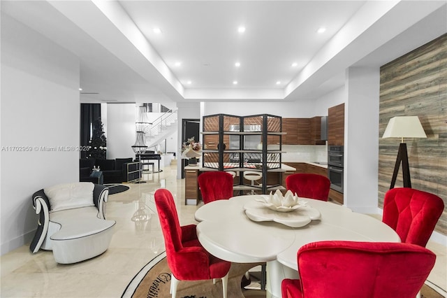 dining space with a raised ceiling