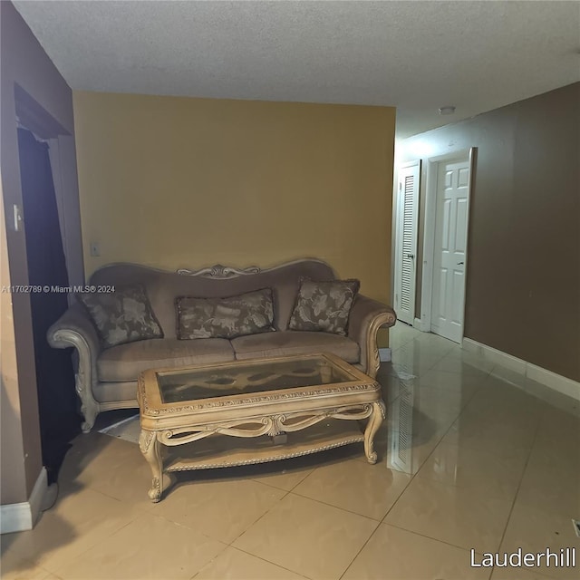 living room featuring a textured ceiling and light tile patterned flooring