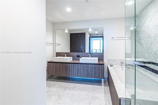 bathroom with vanity and tiled tub