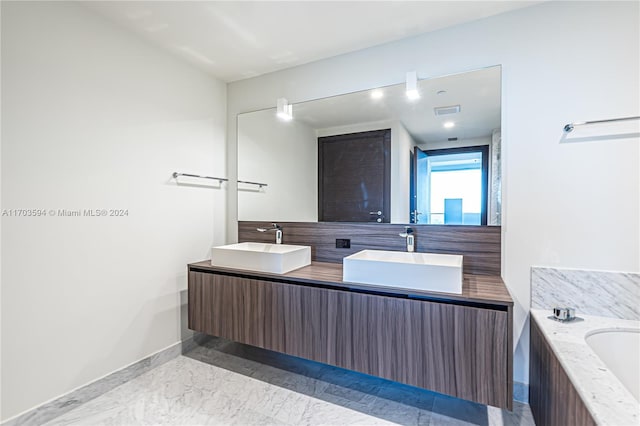 1000 Brickell Plz Unit 3806, Miami, FL 33131 - full bath with double vanity, a bath, marble finish floors, and backsplash