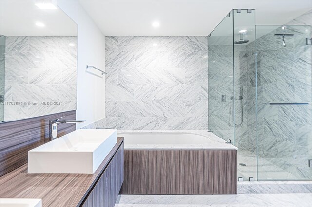 1000 Brickell Plz Unit 3806, Miami, FL 33131 - bathroom featuring a garden tub, a marble finish shower, vanity, and tile walls