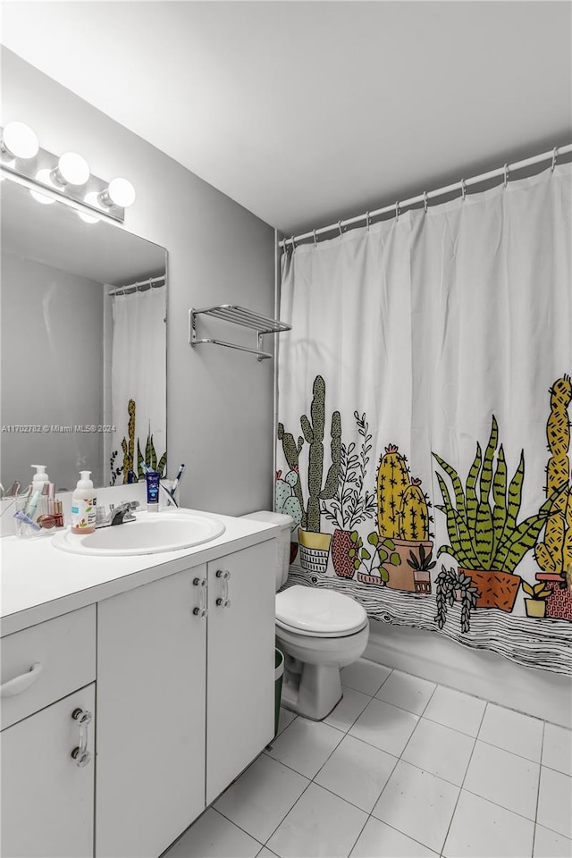 bathroom with toilet, vanity, and tile patterned floors