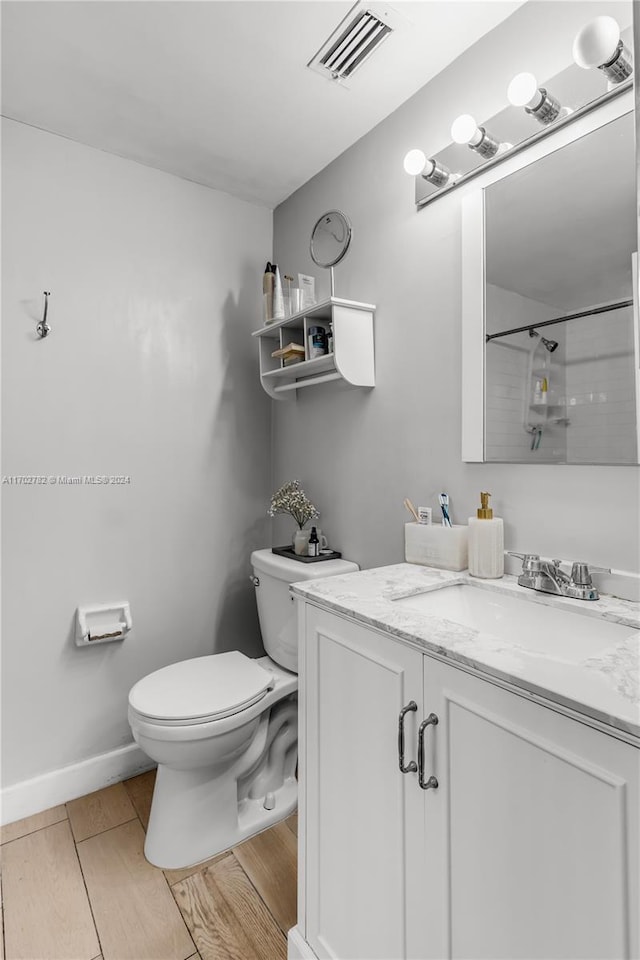 bathroom featuring vanity, toilet, and walk in shower