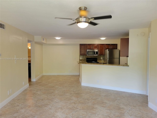 kitchen featuring backsplash, ceiling fan, light stone countertops, appliances with stainless steel finishes, and kitchen peninsula