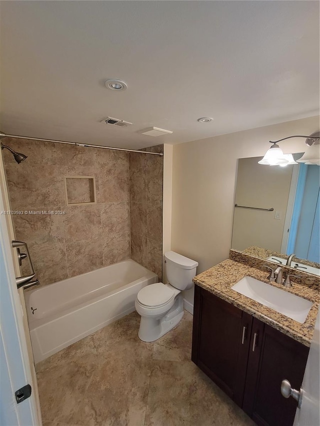 full bathroom featuring toilet, vanity, and tiled shower / bath