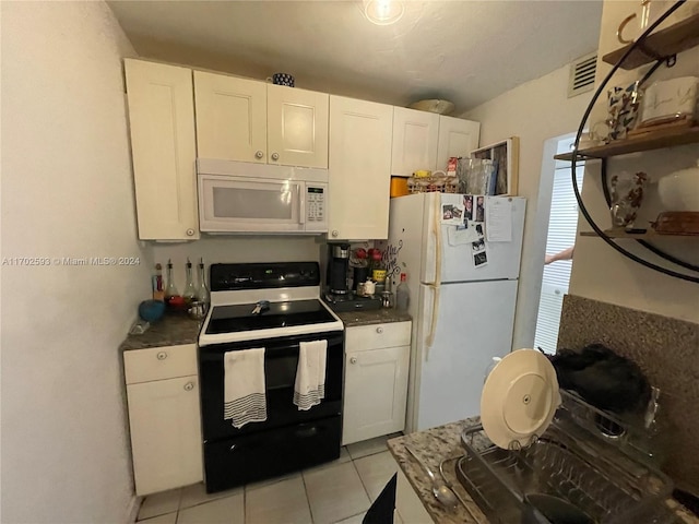 kitchen featuring light tile patterned floors, white cabinets, and white appliances