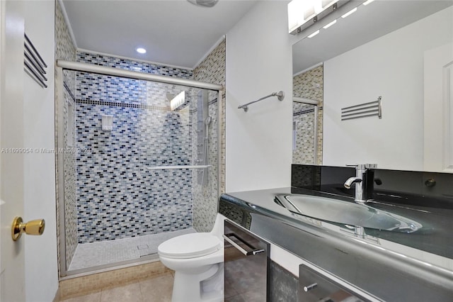 bathroom with tile patterned flooring, vanity, toilet, and a shower with door