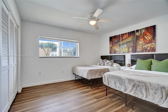 bedroom with ceiling fan, wood-type flooring, and a closet