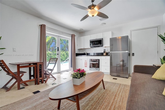 living room featuring ceiling fan, sink, and french doors