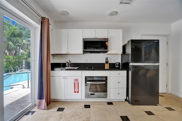 kitchen featuring white cabinets, sink, and black appliances