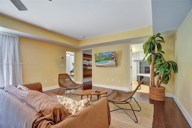 living room with ceiling fan and dark hardwood / wood-style flooring