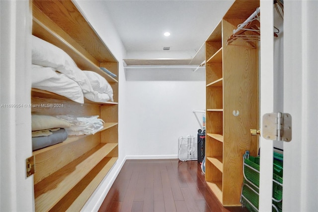 walk in closet with dark hardwood / wood-style flooring