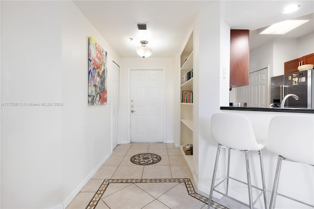 interior space featuring built in shelves and light tile patterned floors