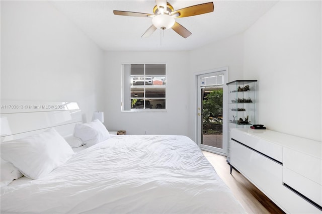 bedroom featuring hardwood / wood-style floors, ceiling fan, access to exterior, and multiple windows