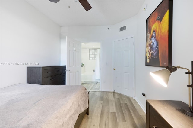 bedroom with ensuite bathroom, ceiling fan, and light hardwood / wood-style floors