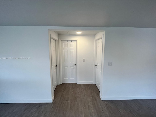 hallway with dark hardwood / wood-style flooring and vaulted ceiling