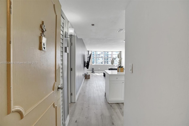 hallway with light hardwood / wood-style floors