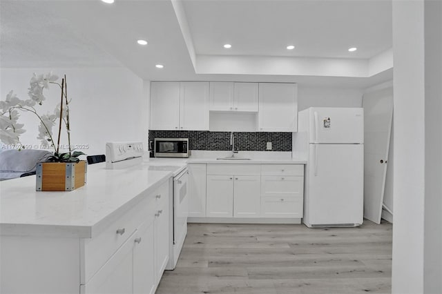 kitchen with sink, white cabinetry, tasteful backsplash, light hardwood / wood-style flooring, and white appliances