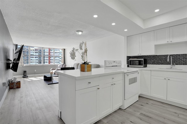 kitchen with sink, light hardwood / wood-style flooring, white electric range oven, white cabinets, and kitchen peninsula