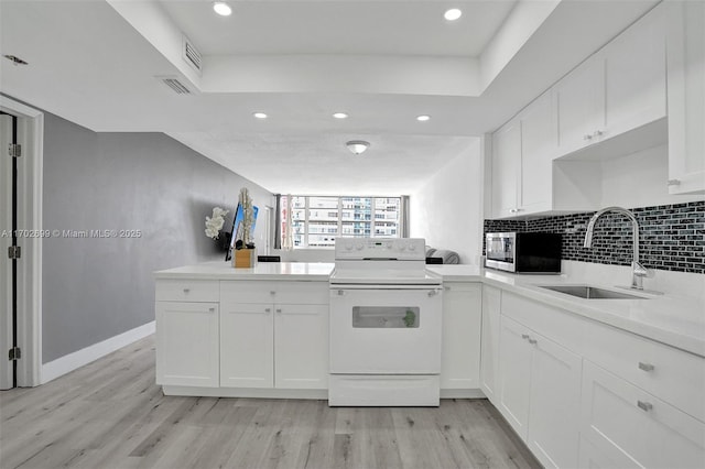 kitchen with sink, white cabinetry, white range with electric stovetop, light hardwood / wood-style floors, and decorative backsplash