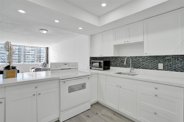 kitchen with white cabinetry, sink, and electric range