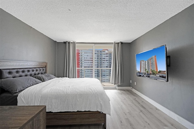 bedroom with light hardwood / wood-style flooring and a textured ceiling