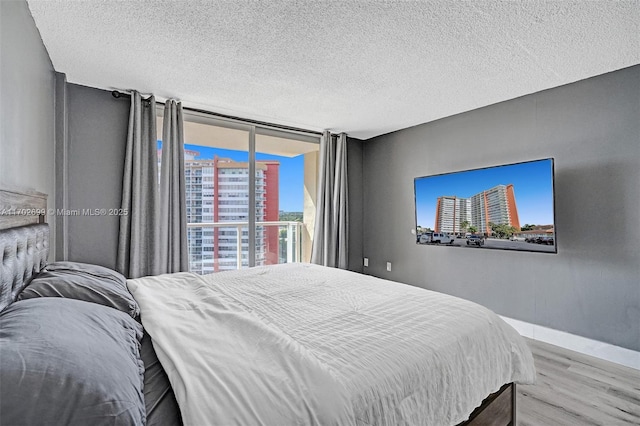 bedroom with light hardwood / wood-style flooring and a textured ceiling