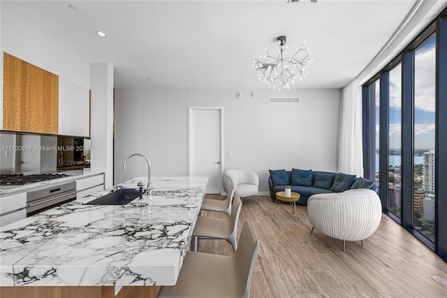 kitchen featuring white cabinets, plenty of natural light, a center island with sink, and stainless steel appliances