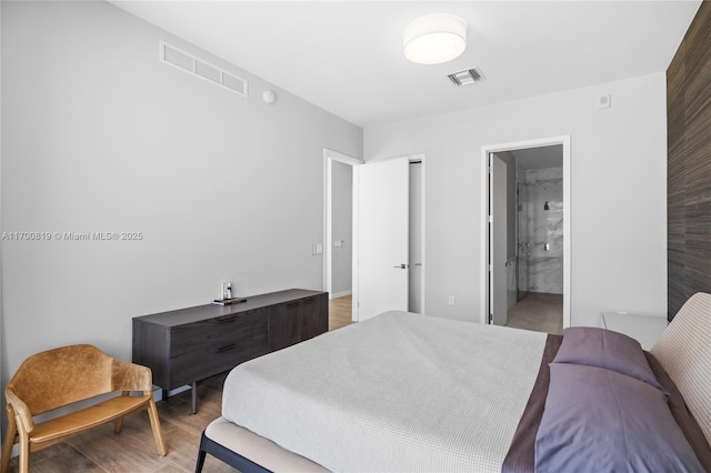 bedroom with wood-type flooring and ensuite bathroom